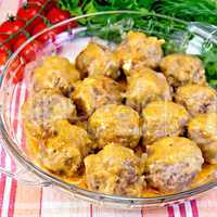 Meatballs with sauce in glass pan on fabric