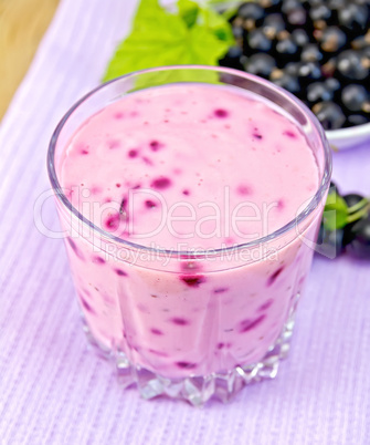 Milkshake with blackcurrants on purple napkin
