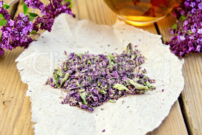 Oregano is dry on the paper with cup on board