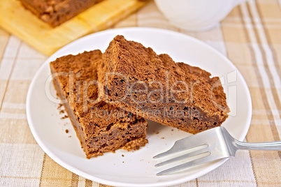 Pie chocolate in plate with fork on tablecloth