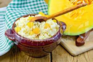 Porridge millet with pumpkin and wooden spoon