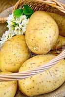 Potatoes yellow in basket with flower on board