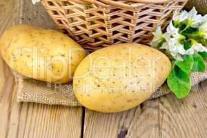 Potatoes yellow with flower and basket on sackcloth