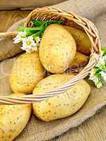 Potatoes yellow with flower in basket on sacking
