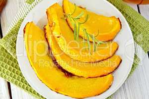 Pumpkin baked with honey in plate on light board