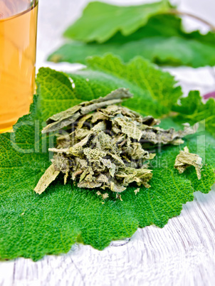 Sage dried on fresh leaves with cup on board