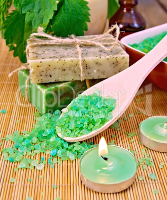 Salt and candles with nettles in mortar on board