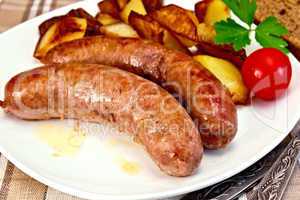 Sausages pork fried with potatoes and tomato on plate