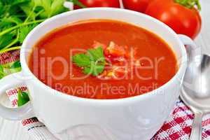 Soup tomato with spoon on napkin and board