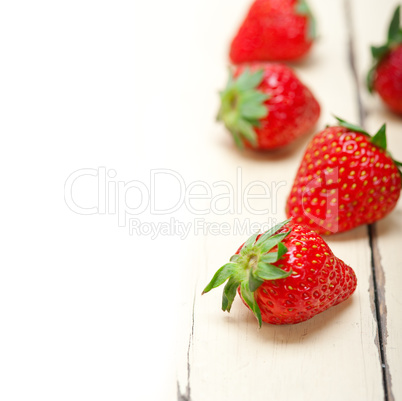 fresh organic strawberry over white wood