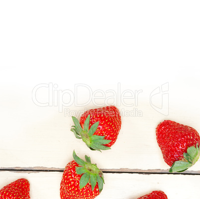 fresh organic strawberry over white wood