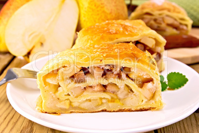 Strudel with pears in bowl on board