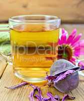 Tea from Echinacea in glass mug with strainer on board