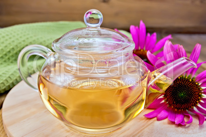 Tea from Echinacea in glass teapot on board with cloth