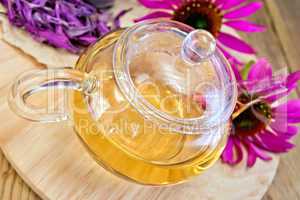Tea from Echinacea in glass teapot on board