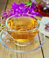 Tea from fireweed in glass cup on board