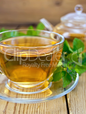 Tea with mint and teapot on wooden board