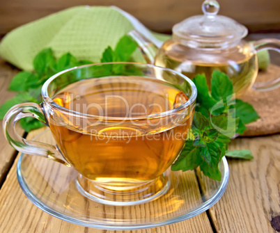 Tea with mint and napkin on wooden board