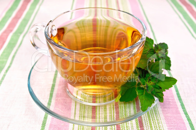 Tea with mint in cup on tablecloth