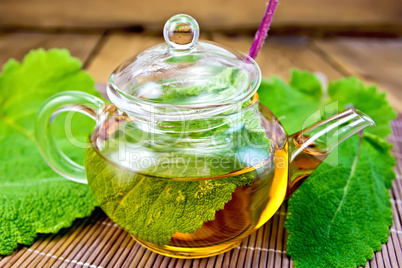 Tea with sage in teapot on bamboo napkin