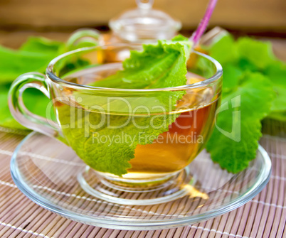 Tea with sage in cup on bamboo napkin