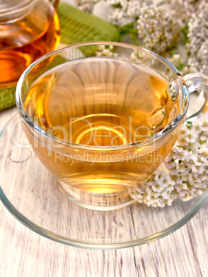 Tea with yarrow in glass cup on board