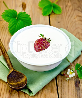 Yogurt thick with strawberries in bowl on board