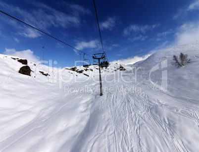 Chair-lift and off-piste slope in sun day