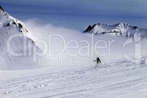 Snowboarder downhill on off-piste slope with newly-fallen snow