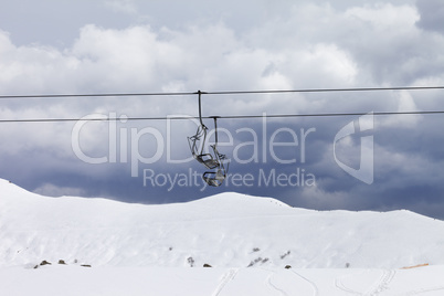 Chair lifts and off-piste slope at gray day