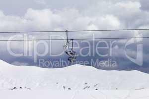 Chair lifts and off-piste slope at gray day