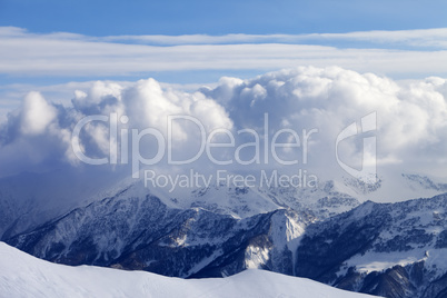 Snowy mountains in clouds and off-piste slope