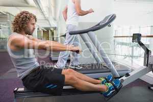 Fit young man on fitness machine at gym