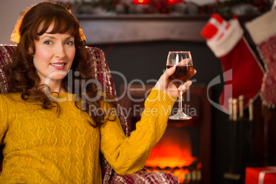 Woman sitting on a couch while holding a glass of red wine