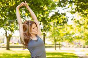 Pretty redhead stretching in the park