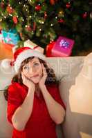 Red hair in santa hat relaxing on the couch at christmas