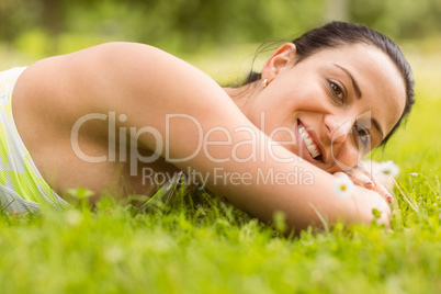Smiling brunette lying on grass