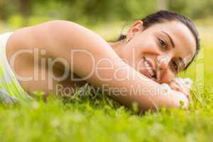 Smiling brunette lying on grass