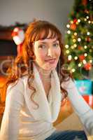 Redhead woman sitting on floor using laptop at christmas