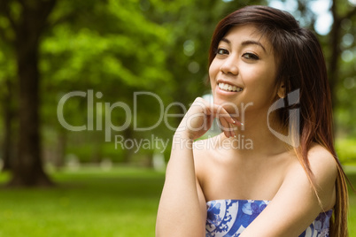 Beautiful woman with hand on chin in park