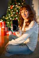 Pretty redhead woman showing you mobile phone