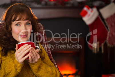 Smiling red hair enjoying hot drink at christmas