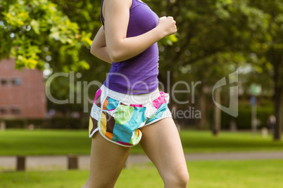 Mid section of healthy woman jogging in park