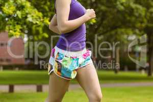 Mid section of healthy woman jogging in park