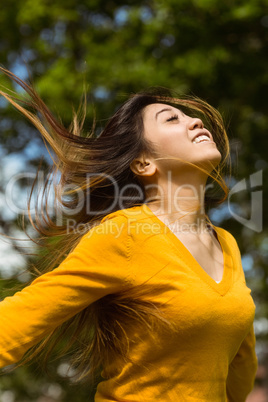 Beautiful woman with arms outstretched in park