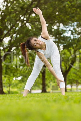 Toned woman doing stretching exercises in park