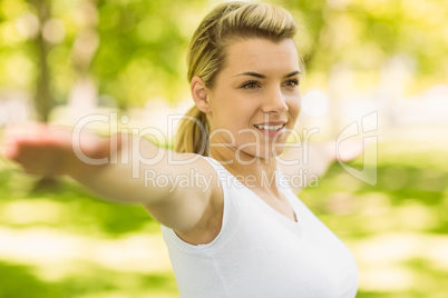 Peaceful blonde doing yoga in the park