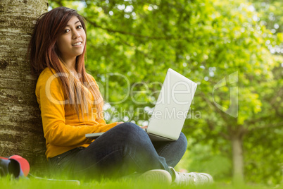 Relaxed woman using laptop in park