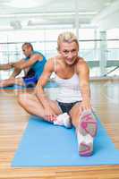 Couple stretching hands in yoga class