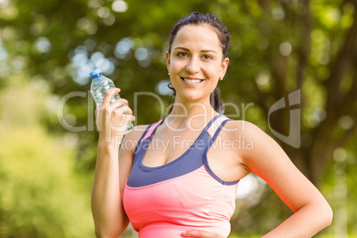 Fit brunette holding her water bottle